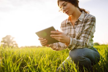 Çiftçiler veri analiz tabletlerinde tarım teknolojisi kullanıyorlar. Kadınlar bitki tarımını araştırmak ve geliştirmek için tablet kullanıyorlar.