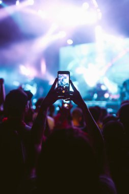 Telefon kayıtlarıyla birlikte canlı müzik festivali. Seyirci kitlesi canlı müzik konserinin tadını çıkarırken akıllı telefonlar kullanıyor. Gençlik, parti, tatil konsepti.