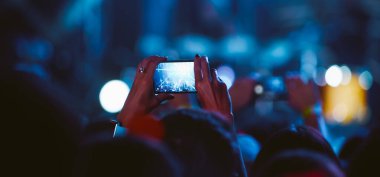 Telefon kayıtlarıyla birlikte canlı müzik festivali. Seyirci kitlesi canlı müzik konserinin tadını çıkarırken akıllı telefonlar kullanıyor. Gençlik, parti, tatil konsepti.