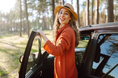 Araba gezisi sırasında durmak. Doğanın tadını çıkaran genç bir kadın. Arabayla yolculuk. Yaşam tarzı, seyahat, turizm, doğa konsepti.