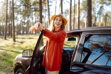 Araba gezisi sırasında durmak. Doğanın tadını çıkaran genç bir kadın. Arabayla yolculuk. Yaşam tarzı, seyahat, turizm, doğa konsepti.