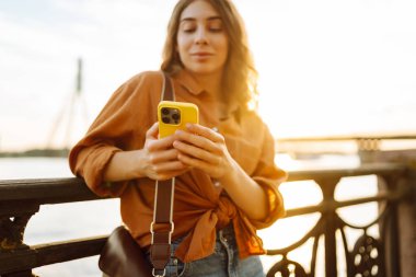 Kadın portresi duvar seti üzerinde telefon yürüyüşü yapar. Avrupa seyahati. Meslek, teknoloji, hafta sonu kavramı