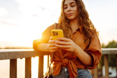 Kadın portresi duvar seti üzerinde telefon yürüyüşü yapar. Avrupa seyahati. Meslek, teknoloji, hafta sonu kavramı