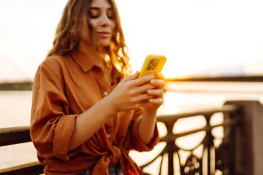 Kadın portresi duvar seti üzerinde telefon yürüyüşü yapar. Avrupa seyahati. Meslek, teknoloji, hafta sonu kavramı