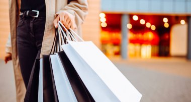 Alışveriş torbalı güzel kadın Avrupa 'nın güneşli sokaklarında yürüyor. Tüketim, alışveriş. Aktif yaşam tarzı. Satılık..
