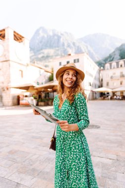 Şehir şehir topografik haritayla gezen maceraperest kadın. Modayı takip eden kadın yazın yurt dışına seyahat ederken haritada yön arıyor. Turizm.