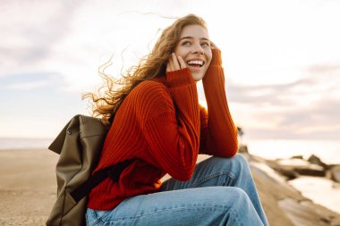 Deniz aşırı deniz fenerine bakan genç bir kadın. Seyahat, hafta sonu, rahatlama ve yaşam tarzı konsepti.