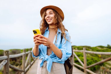 Telefonlu kadın turist güzel manzaranın tadını çıkarıyor. Avrupa seyahati. Yaşam tarzı, tatil, doğa, aktif yaşam.
