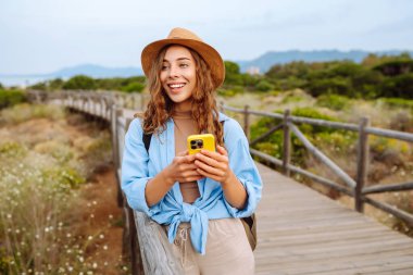 Telefonlu kadın turist güzel manzaranın tadını çıkarıyor. Avrupa seyahati. Yaşam tarzı, tatil, doğa, aktif yaşam.