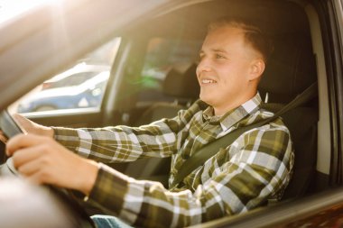 Mutlu adam yeni arabasında sürücü koltuğunda rahatça oturuyor. Araba yolculuğu, yaşam tarzı konsepti. Araba paylaşım kavramı.