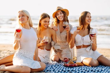 Plaj partisi. Şarap kadehli bir grup genç kadın sahilde eğleniyor, sahilde bekarlığa veda partisini kutluyor ve tatillerinin tadını çıkarıyorlar..
