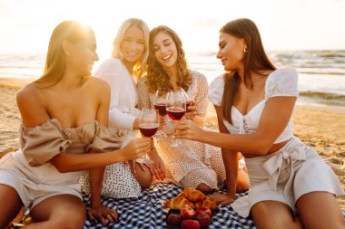Plaj partisi. Şarap kadehli bir grup genç kadın sahilde eğleniyor, sahilde bekarlığa veda partisini kutluyor ve tatillerinin tadını çıkarıyorlar..