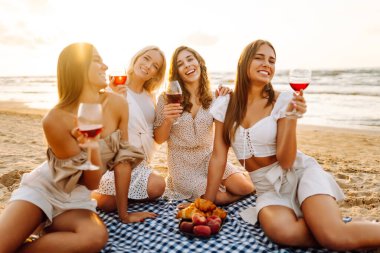 Plaj partisi. Şarap kadehli bir grup genç kadın sahilde eğleniyor, sahilde bekarlığa veda partisini kutluyor ve tatillerinin tadını çıkarıyorlar..