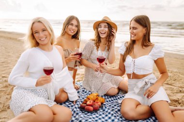 Plaj partisi. Şarap kadehli bir grup genç kadın sahilde eğleniyor, sahilde bekarlığa veda partisini kutluyor ve tatillerinin tadını çıkarıyorlar..
