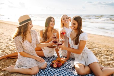 Plaj partisi. Şarap kadehli bir grup genç kadın sahilde eğleniyor, sahilde bekarlığa veda partisini kutluyor ve tatillerinin tadını çıkarıyorlar..