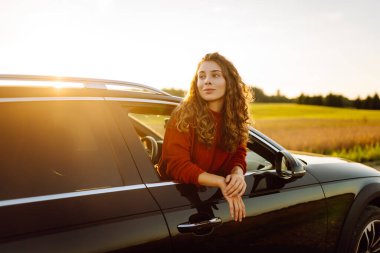 Maceraya doğru! Yaz gezisi. Genç bayan araba yolculuğunun tadını çıkarıyor. Aktif yaşam tarzı, seyahat