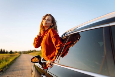 Maceraya doğru! Yaz gezisi. Genç bayan araba yolculuğunun tadını çıkarıyor. Aktif yaşam tarzı, seyahat