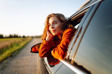 Maceraya doğru! Yaz gezisi. Genç bayan araba yolculuğunun tadını çıkarıyor. Aktif yaşam tarzı, seyahat