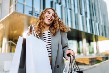 Alışveriş zamanı. Alışveriş torbalı şık bir kadın şehrin sokaklarında yürüyor. Satışlar. Kara Cuma.