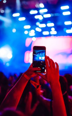 Telefon kayıtlarıyla birlikte canlı müzik festivali. Akıllı telefonla fotoğraf çeken insanlar..
