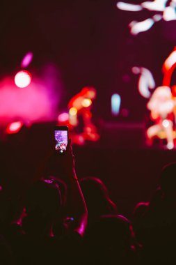 Telefon kayıtlarıyla birlikte canlı müzik festivali. Akıllı telefonla fotoğraf çeken insanlar..