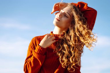 Güneşli sahilde rüzgarın tadını çıkaran rahat kadın portresi. Güzel bir kadın denizin yanında özgürlüğünü hisseder. Keyif, rahatlama, özgürlük kavramı.