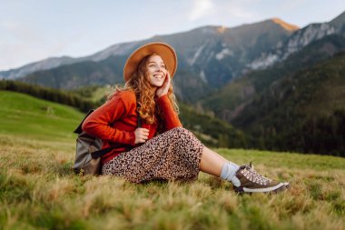 Sırt çantalı mutlu kadın turist dağ vadisinde tek başına seyahat ediyor. Seyahat, doğa konsepti.