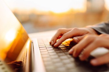 Dişi eller dışarıda dizüstü bilgisayarda çalışıyor. İş, eğitim, alışveriş. Çevrimiçi