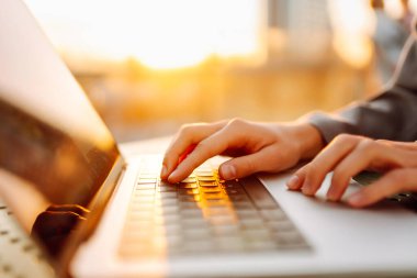 Dişi eller dışarıda dizüstü bilgisayarda çalışıyor. İş, eğitim, alışveriş. Çevrimiçi