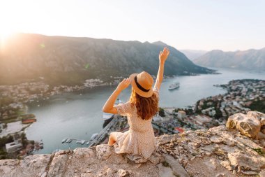 Turist kadının arka görüntüsü körfeze ve şehre bir gözlem güvertesinden bakıyor. Avrupa seyahati. Yaşam tarzı, tatil, turizm, doğa, aktif yaşam