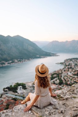 Turist kadının arka görüntüsü körfeze ve şehre bir gözlem güvertesinden bakıyor. Avrupa seyahati. Yaşam tarzı, tatil, turizm, doğa, aktif yaşam