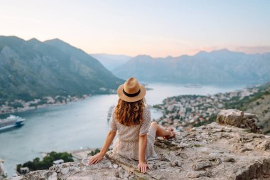 Turist kadının arka görüntüsü körfeze ve şehre bir gözlem güvertesinden bakıyor. Avrupa seyahati. Yaşam tarzı, tatil, turizm, doğa, aktif yaşam