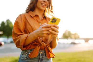 Akıllı telefon tutan, çevrimiçi uygulama ve sanal servis cep telefonu kullanan video telefon görüşmesi yapan, kuryelerle mesajlaşan ve sohbet eden, internetten alışveriş yapan kadınların elleri. Blog yazıyorum. Kapat.