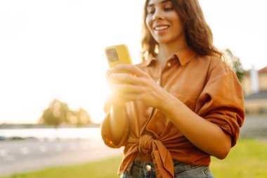 Akıllı telefon tutan, çevrimiçi uygulama ve sanal servis cep telefonu kullanan video telefon görüşmesi yapan, kuryelerle mesajlaşan ve sohbet eden, internetten alışveriş yapan kadınların elleri. Blog yazıyorum. Kapat.