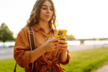 Akıllı telefon tutan, çevrimiçi uygulama ve sanal servis cep telefonu kullanan video telefon görüşmesi yapan, kuryelerle mesajlaşan ve sohbet eden, internetten alışveriş yapan kadınların elleri. Blog yazıyorum. Kapat.
