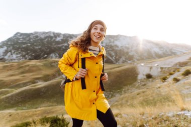Kadın turist, sırt çantasıyla dağlarda durmuş manzarayı seyrediyor. Ulusal Park 'ta vahşi doğayı keşfediyorum. Seyahat, yürüyüş konsepti