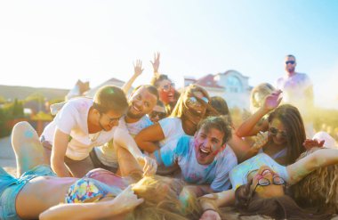 Mutlu arkadaşlar gün batımı kumsalında eğleniyorlar. Bir grup arkadaş birlikte vakit geçirip dışarıda festivali kutluyorlar. Holly kutlamaları. Arkadaşlık, eğlence konsepti..