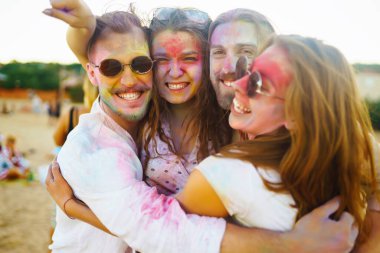 Mutlu arkadaşlar gün batımı kumsalında eğleniyorlar. Bir grup arkadaş birlikte vakit geçirip dışarıda festivali kutluyorlar. Holly kutlamaları. Arkadaşlık, eğlence konsepti..