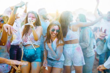 Mutlu arkadaşlar gün batımı kumsalında eğleniyorlar. Bir grup arkadaş birlikte vakit geçirip dışarıda festivali kutluyorlar. Holly kutlamaları. Arkadaşlık, eğlence konsepti..