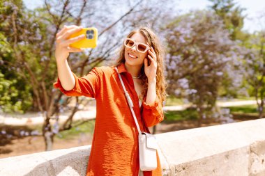 Selfie zamanı. Güneşli bir günde fotoğraf çeken ya da blog yazan güzel bir kadın. İyi tatiller. Bloglama, tatil kavramı.