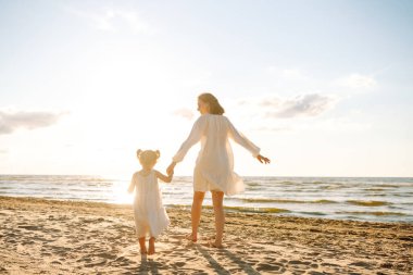 Güzel bir kadın ve çocuğu gün batımı kumsalında yürüyor. Genç bir anne ve kızı gün batımının tadını çıkarıp birlikte vakit geçiriyorlar. Hafta sonu, tatil kavramı.
