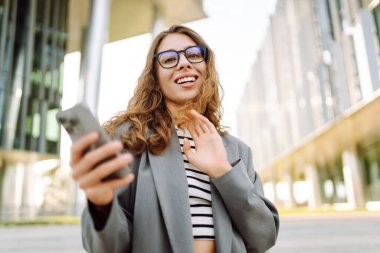 Şık giyinmiş, telefon kulübesinde oturan güzel bir kadın. Genç iş kadını dışarıda günbatımını seyrediyor. İş, günlük tutma kavramı.
