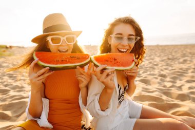 Denize yakın bir piknikte karpuz yiyen iki genç bayan arkadaş. Güzel kadınlar gün batımında eğleniyor ve deniz manzarasının tadını çıkarıyor. Arkadaşlık kavramı, birlikte zaman geçirmek..
