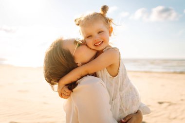 Güzel bir kadın kızıyla denizde eğleniyor. Mutlu anne ve çocuk gün batımında eğleniyor ve dışarıda birlikte vakit geçiriyorlar. Annelik ve aşk kavramı.