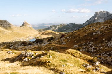 Gün batımında dağ manzarası. Mavi gökyüzü ile kayalık arazi. Doğa, güzellik ve yalnızlık kavramı.