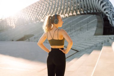 Atletik kadın dışarıda egzersiz yapıyor. Spor kıyafetleriyle gün batımında egzersiz yapan güzel bir kadın. Spor konsepti. Etkin yaşam biçimi.