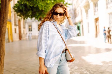 Güneşli Avrupa caddelerinde gezinen güzel turistler havanın tadını çıkarıyorlar. Mimariye bakan neşeli bir kadın. Aktif yaşam tarzı. Yürüme konsepti.