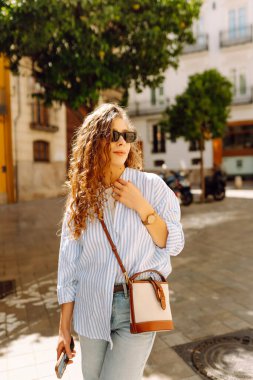 Güneşli Avrupa caddelerinde gezinen güzel turistler havanın tadını çıkarıyorlar. Mimariye bakan neşeli bir kadın. Aktif yaşam tarzı. Yürüme konsepti.