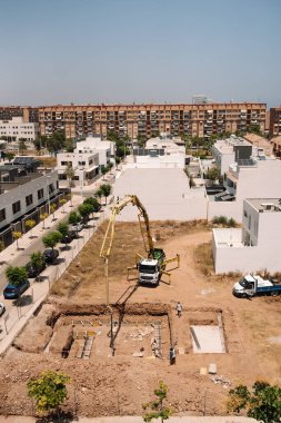 Valencia, İspanya - 20 Haziran 2025: Kentsel yerleşim alanına beton pompa kamyonu döken inşaat alanı, modern mimari ve geliştirme ilerlemelerini gözler önüne seriyor