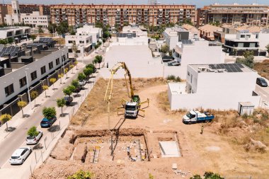 Valencia, İspanya - 20 Haziran 2025: Kentsel yerleşim alanına beton pompa kamyonu döken inşaat alanı, modern mimari ve geliştirme ilerlemelerini gözler önüne seriyor
